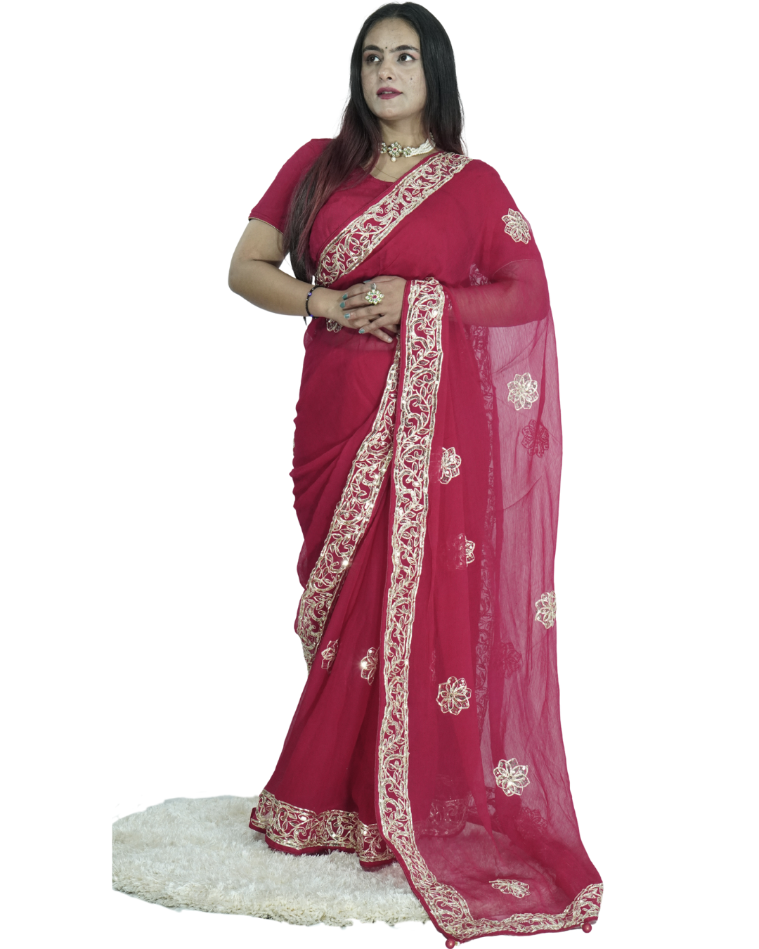 Full-length view of a woman modeling an elegant deep red saree with intricate gold embroidered vine border and scattered floral butta motifs, featuring a sheer flowing pallu and paired with traditional jewelry. ✨