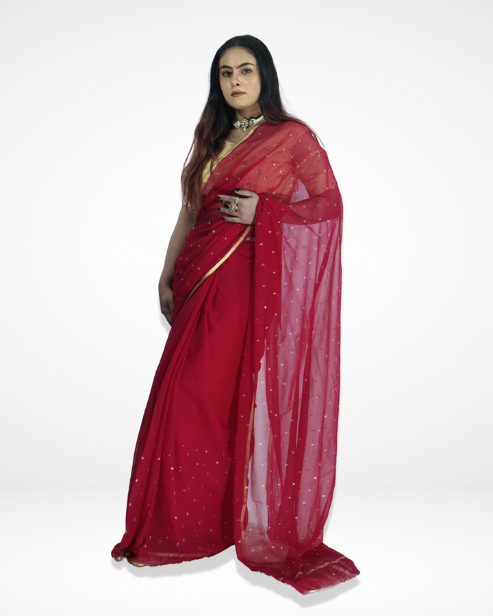 Model wearing a red georgette saree with delicate silver sequin embellishments and minimal gold border, showcasing Amai Jaipur’s elegant handcrafted designer saree perfect for festive occasions, party wear, and modern ethnic fashion.