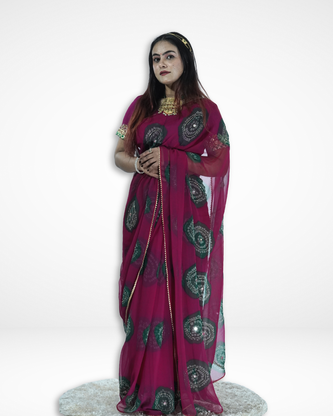 Full-length view of a model wearing a deep magenta chiffon saree with intricate green circular bandhani-style motifs and delicate border detailing, showcasing Amai Jaipur’s elegant designer saree perfect for festive and traditional occasions. ✨