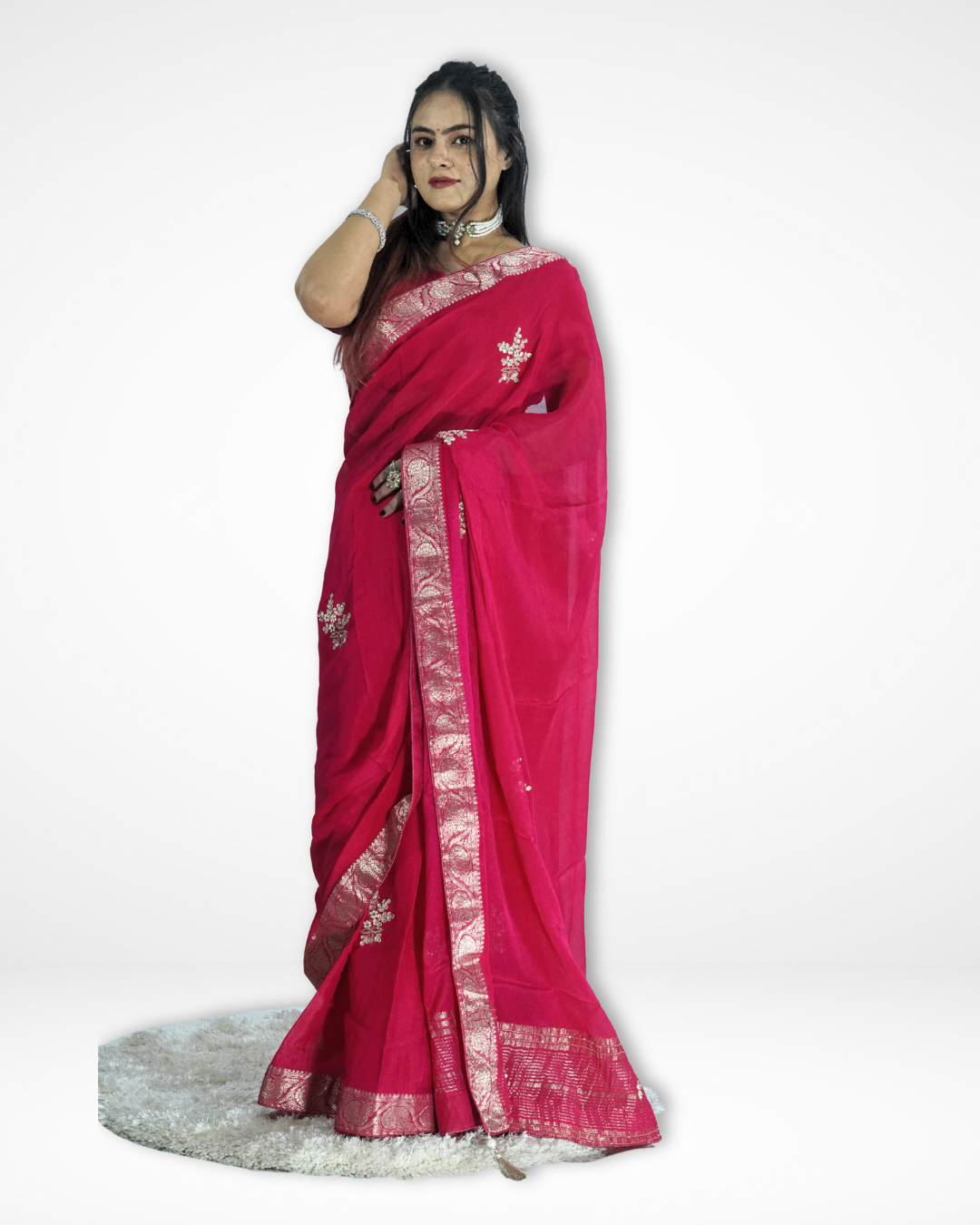 Model wearing a vibrant pink saree with an elegant silver zari border and delicate embroidered motifs, gracefully draped to highlight its flowing pallu and festive charm. ✨