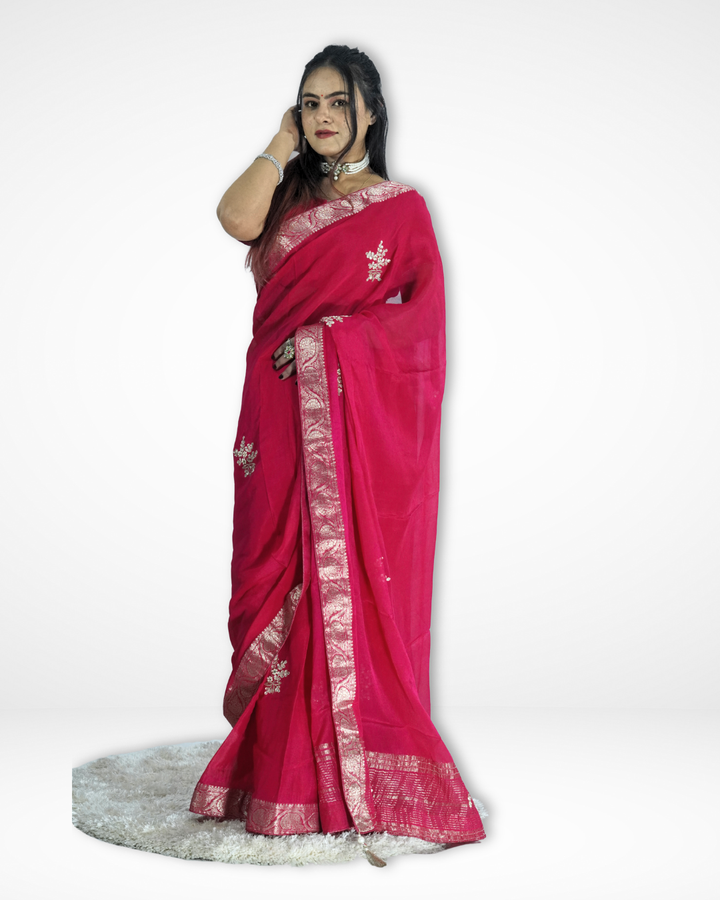 Model wearing a vibrant pink saree with an elegant silver zari border and delicate embroidered motifs, gracefully draped to highlight its flowing pallu and festive charm. ✨