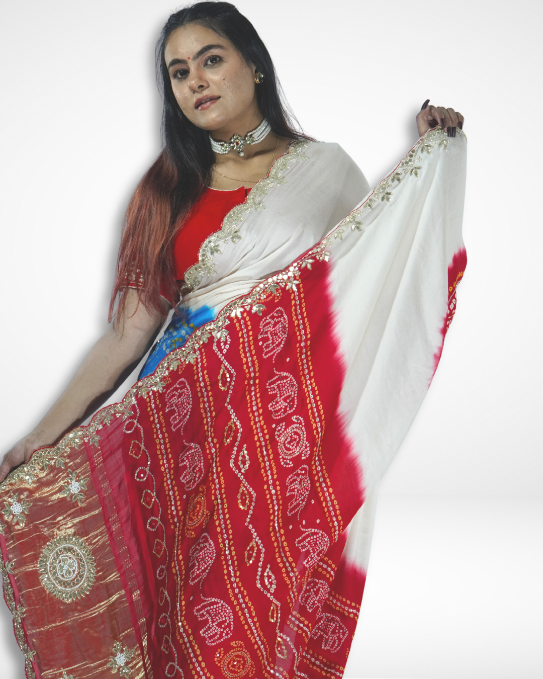 Model showcasing an ivory handcrafted saree with vibrant red bandhani-style patterns and gold embroidered border, highlighting Amai Jaipur’s sustainable luxury ethnic wear inspired by traditional Jaipur craftsmanship.