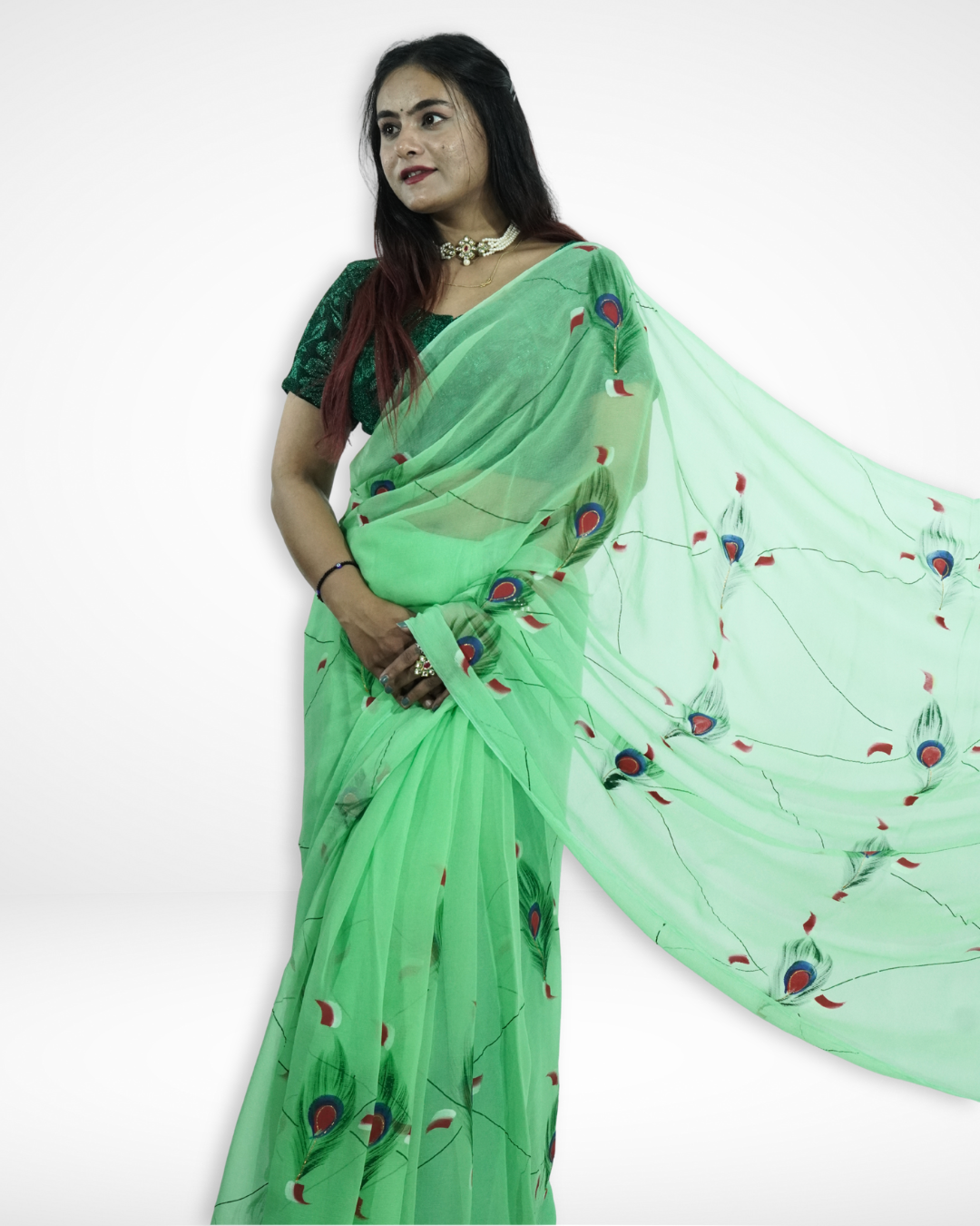 Model gracefully showcasing a mint green chiffon saree with artistic peacock feather motifs and a flowing pallu, highlighting Amai Jaipur’s handcrafted designer saree perfect for festive occasions, summer weddings, and elegant ethnic fashion.