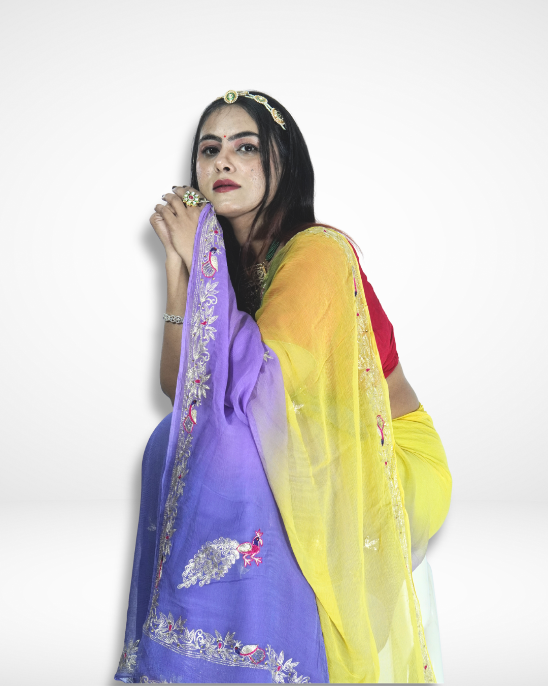 Elegant portrait of a woman wearing a vibrant multicolor saree with purple and yellow gradient drape, detailed embroidered borders featuring peacock motifs, styled with a gold headpiece and traditional jewelry. ✨