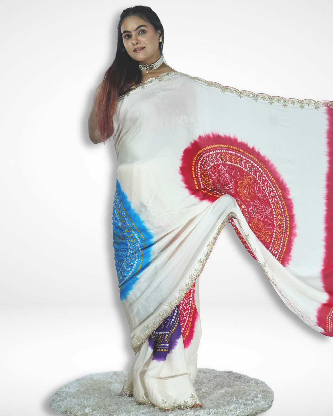 Model elegantly displaying an ivory handcrafted saree with bold red and blue bandhani-inspired circular motifs and delicate embroidered border, showcasing Amai Jaipur’s sustainable luxury ethnic wear rooted in Jaipur craftsmanship.