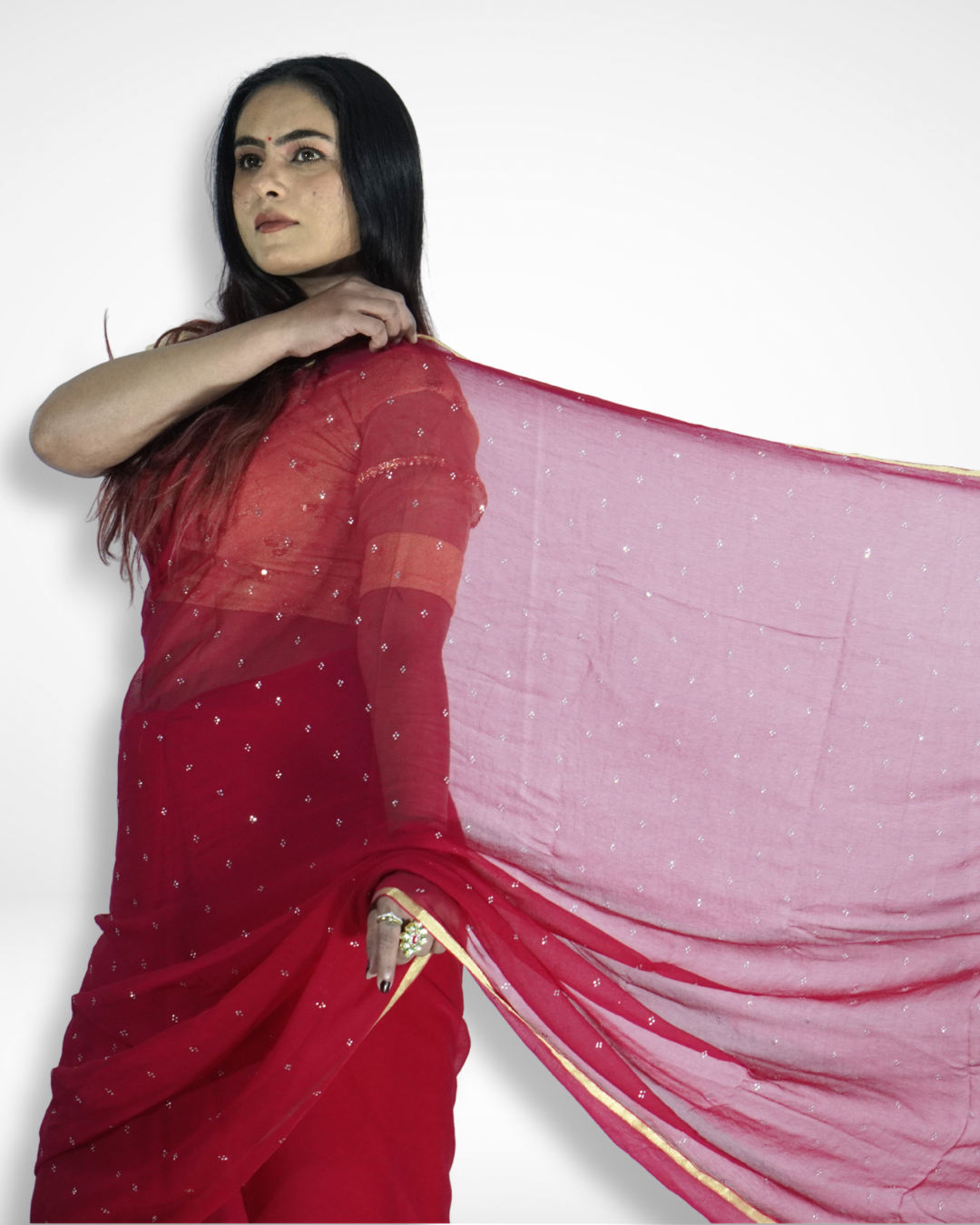 Model gracefully showcasing a flowing red georgette saree with delicate silver sequin embellishments and a subtle gold border, highlighting Amai Jaipur’s elegant handcrafted designer saree perfect for festive occasions, evening parties, and modern ethnic fashion.