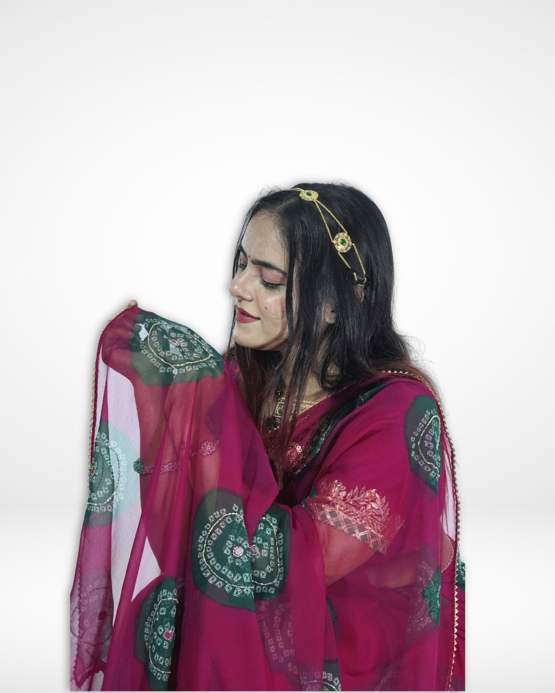 Close-up of a model in a deep magenta chiffon saree with green bandhani-inspired circular motifs, gently holding the pallu to highlight the sheer texture and elegant detailing of Amai Jaipur’s festive designer saree. ✨
