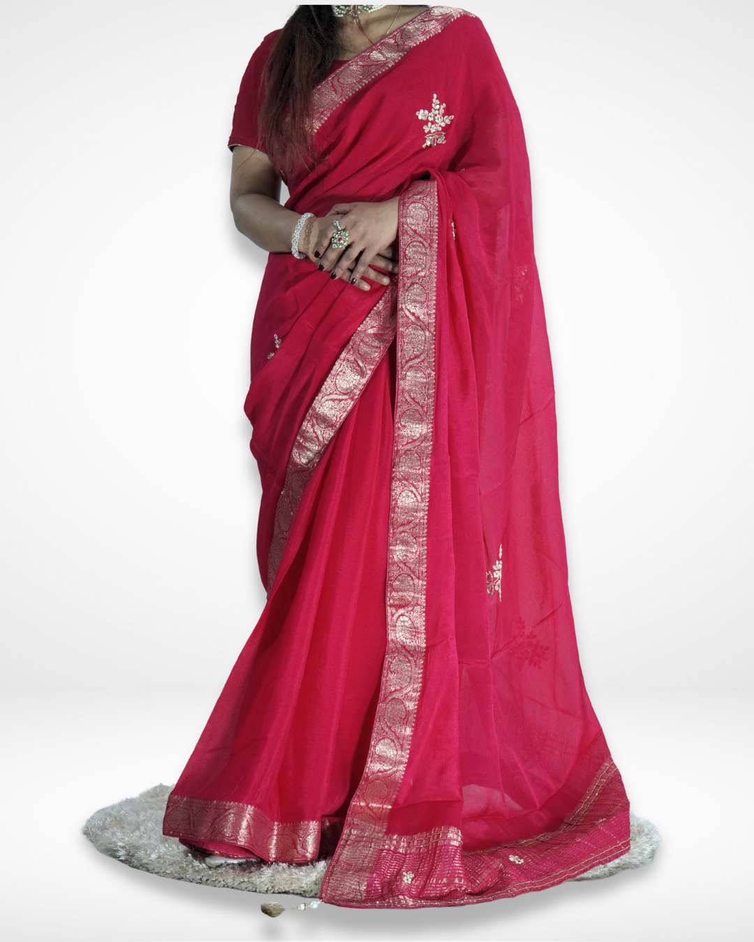 Detailed view of a vibrant pink saree featuring an elegant silver zari border and delicate embroidered floral motifs, beautifully draped to highlight its graceful folds and festive appeal. ✨
