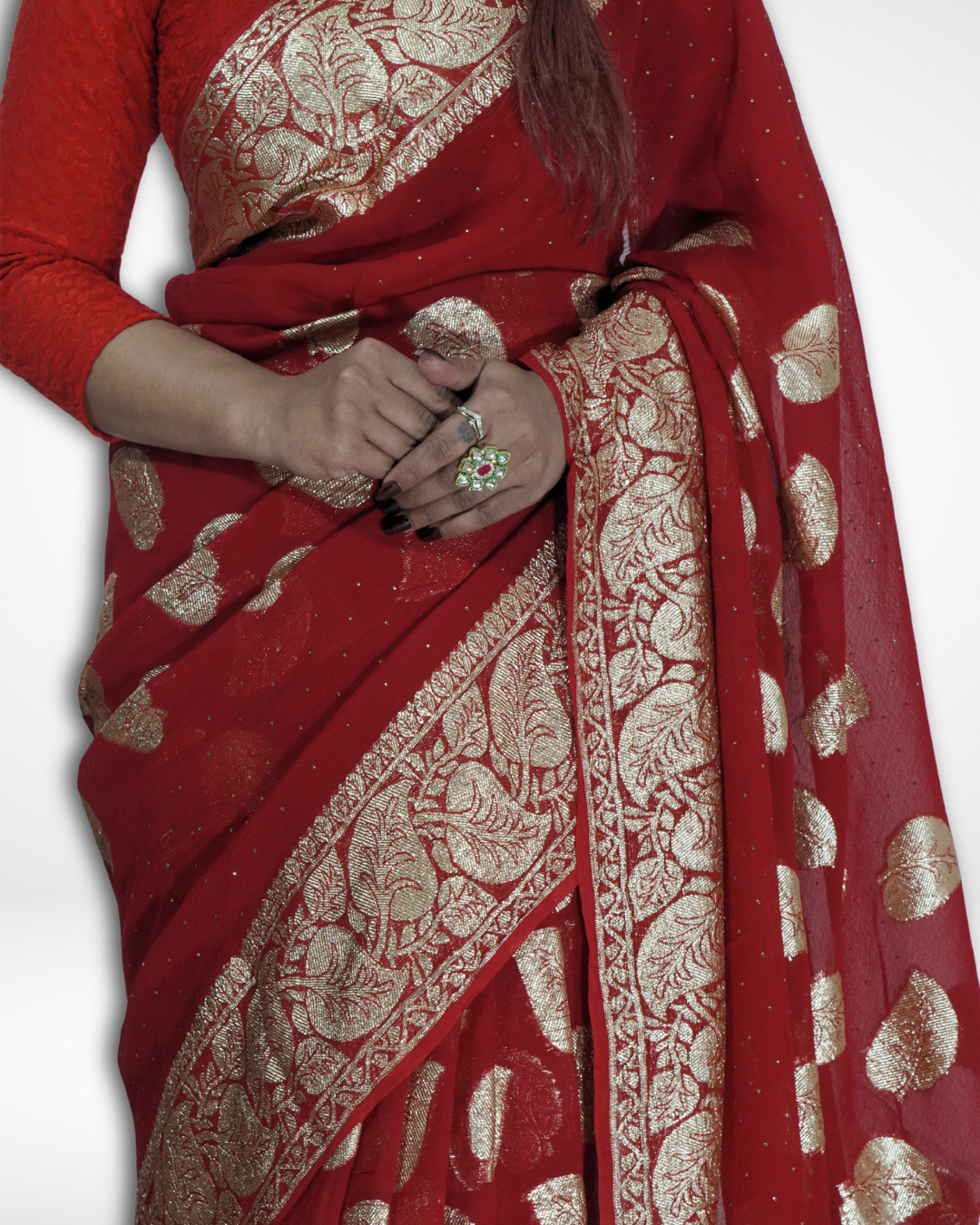 Close-up of a red Banarasi chiffon saree with intricate gold zari woven border and leaf motifs, showcasing Amai Jaipur’s handcrafted luxury saree designed for bridal wear, weddings, and festive ethnic elegance.