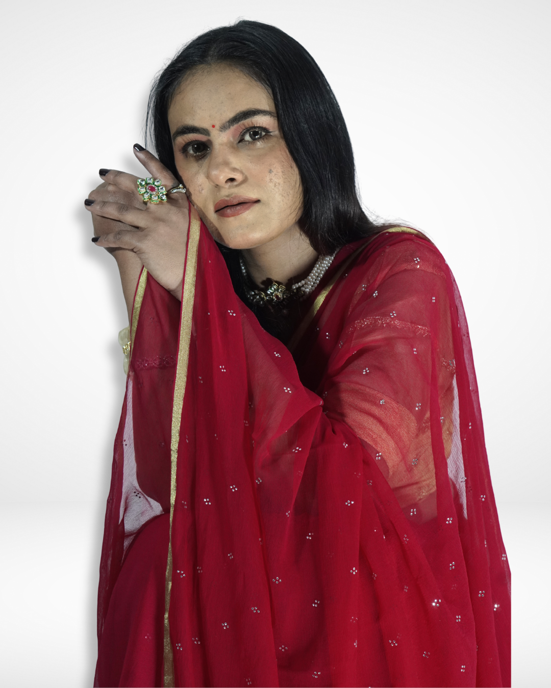 Close-up portrait of a model wearing a red georgette saree with delicate silver sequin embellishments and a minimal gold border, showcasing Amai Jaipur’s handcrafted designer saree perfect for festive occasions, evening wear, and elegant ethnic fashion.