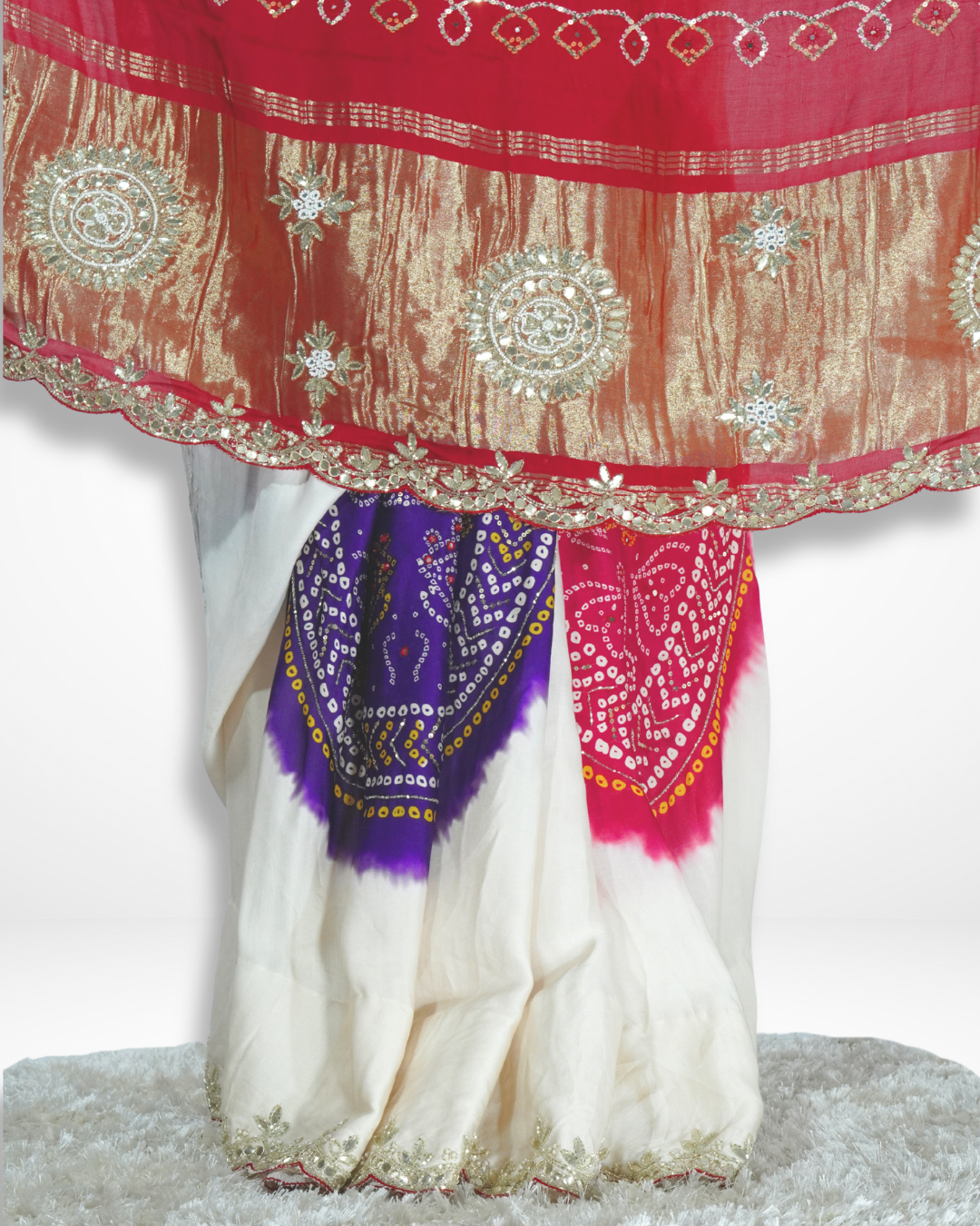 Close-up of a handcrafted saree border featuring rich gold zari embroidery with traditional motifs, paired with vibrant red and purple bandhani patterns, showcasing Amai Jaipur’s sustainable luxury saree craftsmanship.