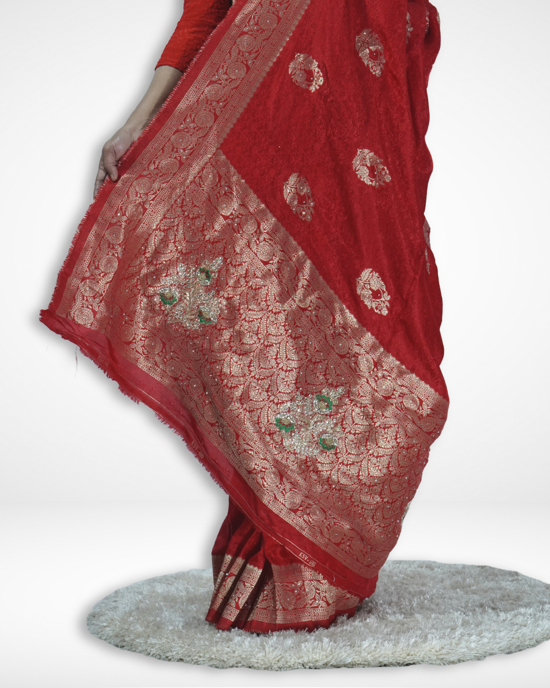 Detailed close-up of a red Banarasi silk saree pallu with intricate gold zari weaving and traditional floral motifs, showcasing Amai Jaipur’s handcrafted luxury bridal saree perfect for weddings and festive ethnic wear.