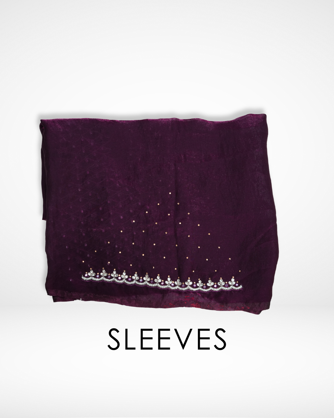 Folded deep wine-purple blouse sleeves featuring subtle shimmer, delicate embroidered border detailing, and scattered bead accents that complement the saree design. ✨