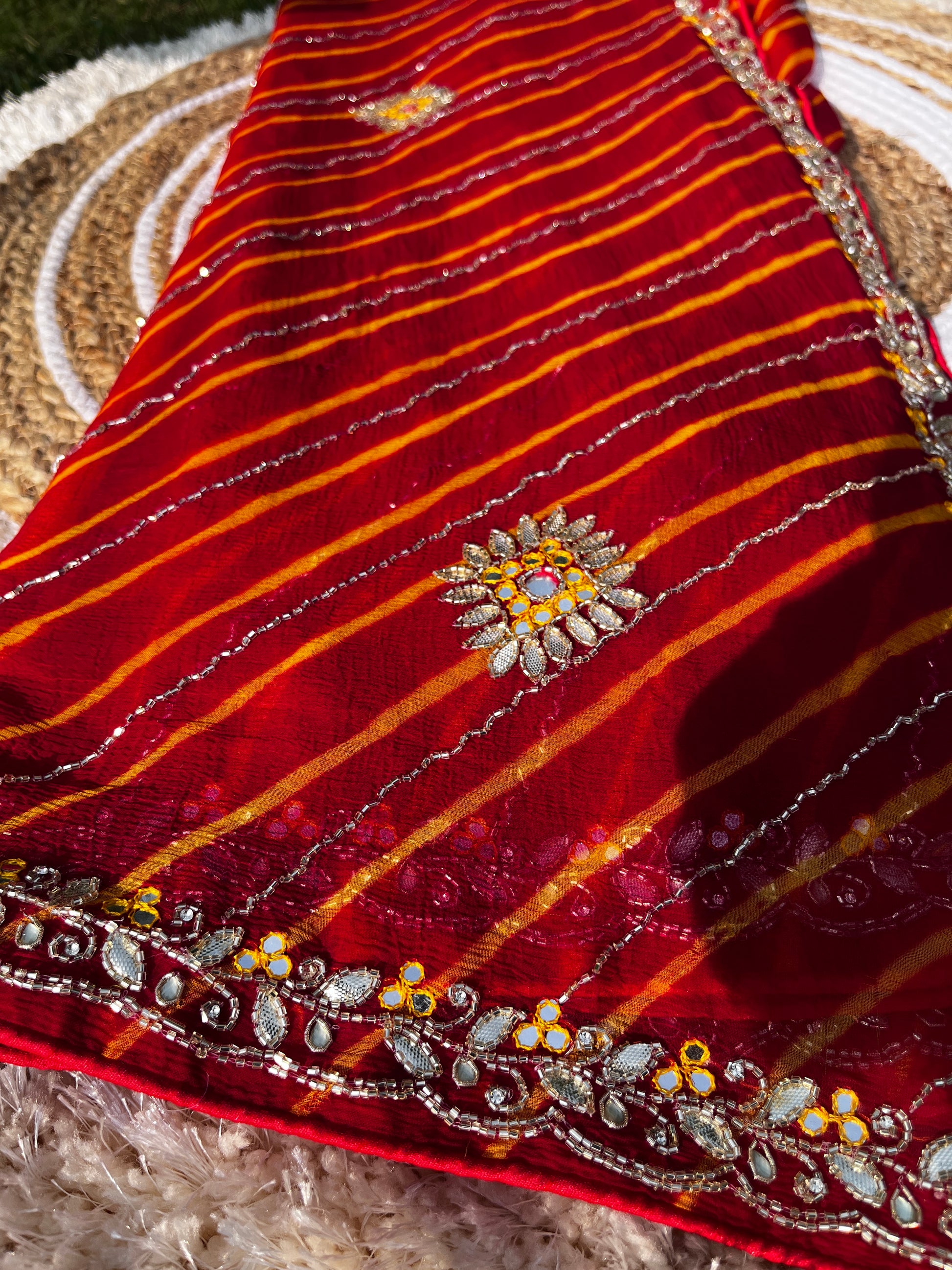 Vibrant Red Lehariya Pure Chiffon Saree featuring Heavy Kardhana and Gotta Patti Butta Work. Traditional Rajasthani handwork for wedding and festive wear. This Picture has a full focus on the Lehariya and Butta work of the Saree.