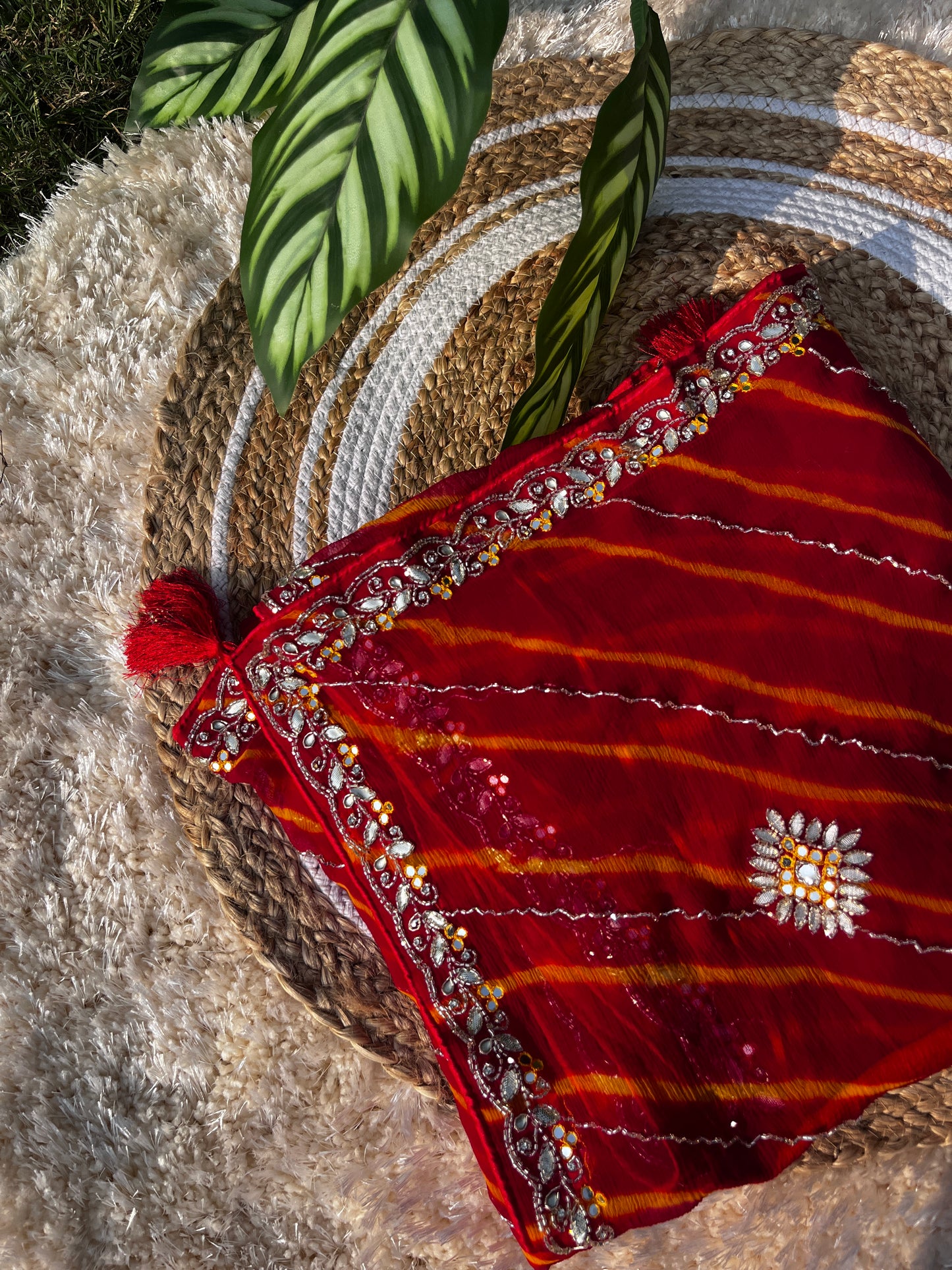 Vibrant Red Lehariya Pure Chiffon Saree featuring Heavy Kardhana and Gotta Patti Butta Work. Traditional Rajasthani handwork for wedding and festive wear. A properly folded Saree showcasing Intricate Handwork.