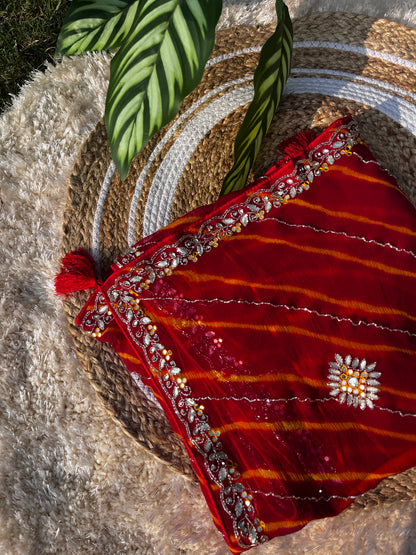 Vibrant Red Lehariya Pure Chiffon Saree featuring Heavy Kardhana and Gotta Patti Butta Work. Traditional Rajasthani handwork for wedding and festive wear. A properly folded Saree showcasing Intricate Handwork.