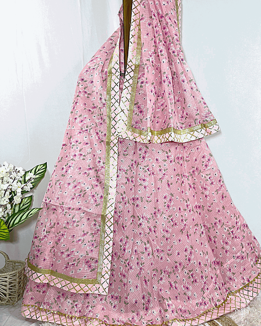 Full view of the multicolored Rajasthani Bandhani Lehenga Ghagra Choli set, draped on a stand, highlighting the vibrant pink, orange, and green Bandhej patterns and extensive floral Gota Patti handwork.