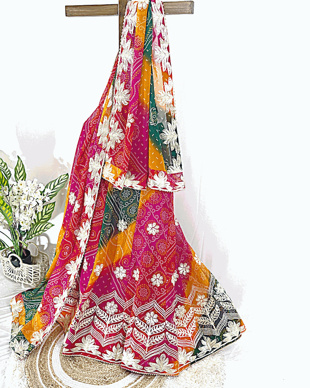 Multicolored Rajasthani Bandhani Lehenga Choli set with a beautifully draped dupatta and flared skirt, featuring intricate Gota Patti work, perfect for traditional Indian parties.