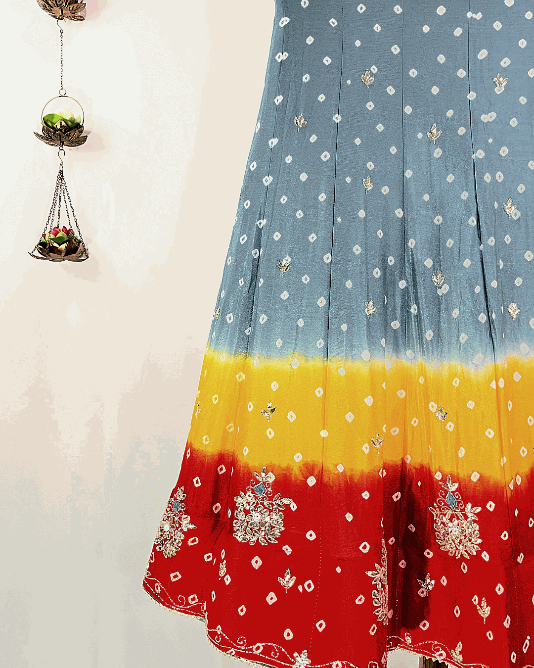 Close-up view of the multicolored Rajasthani Bandhani Lehenga skirt flare, highlighting the heavy floral Gota Patti border embroidery on vibrant pink, orange, and green Bandhej fabric, suitable for wedding and festive wear.
