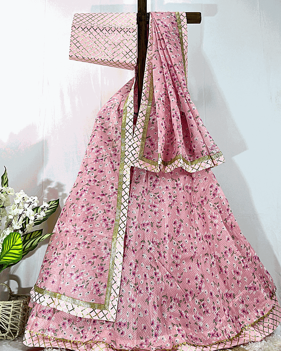 Full display of a traditional Rajasthani Bandhej Lehenga Choli set on a stand, featuring vibrant multicolored tie-dye patterns and heavy floral Gota Patti embroidery on the borders, suitable for weddings and festivals.