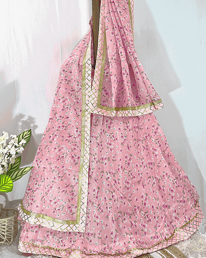 Light Pink Floral Print Lehenga Skirt and Dupatta set featuring intricate Gold Gota Patti border work, displayed on a wooden stand for festive wear.