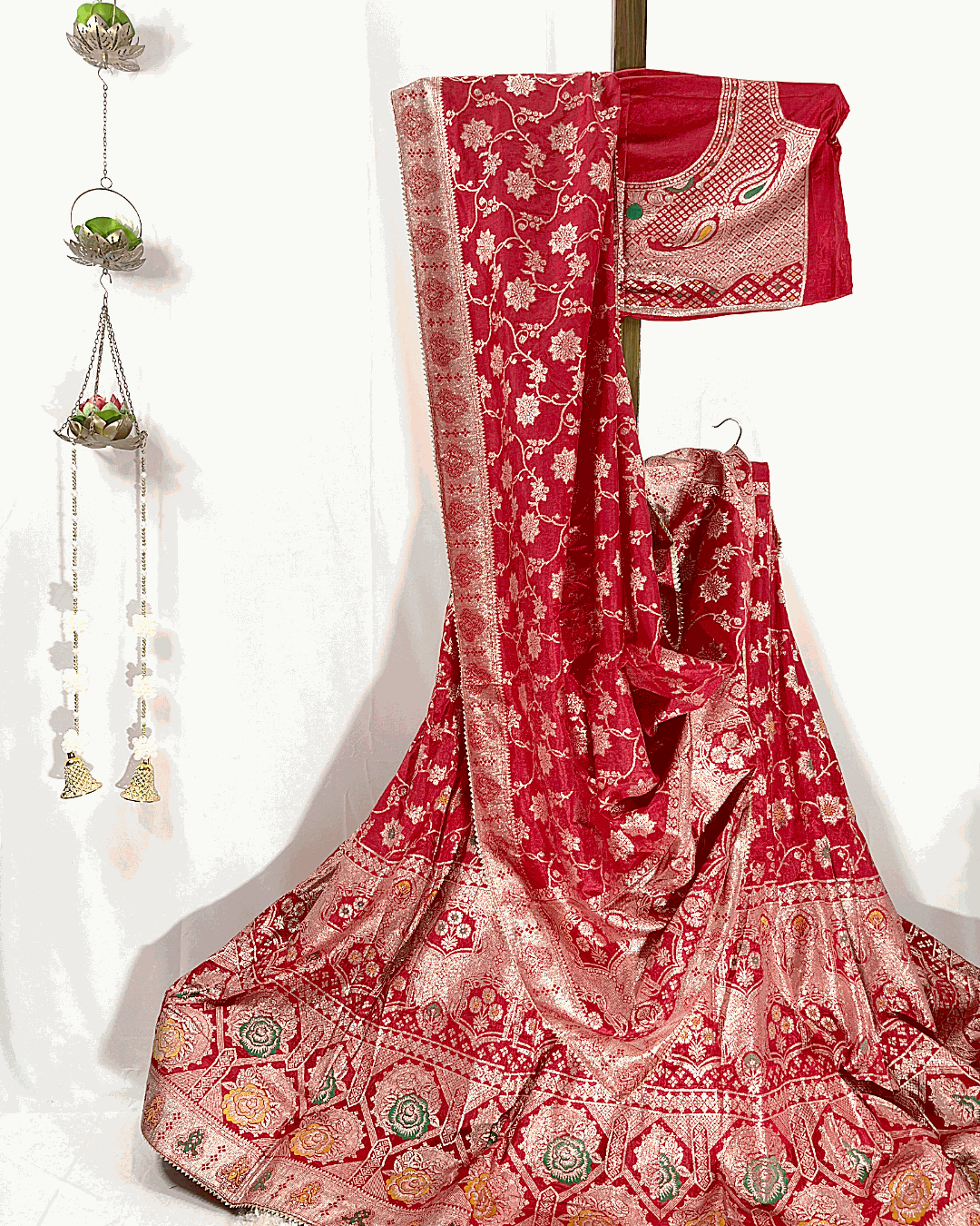 Full display of a traditional Red Dola Silk Lehenga Choli set featuring intricate Meenakari Zari Weaving, complete with a matching dupatta and unstitched blouse piece, ideal for bridal and festive wear.